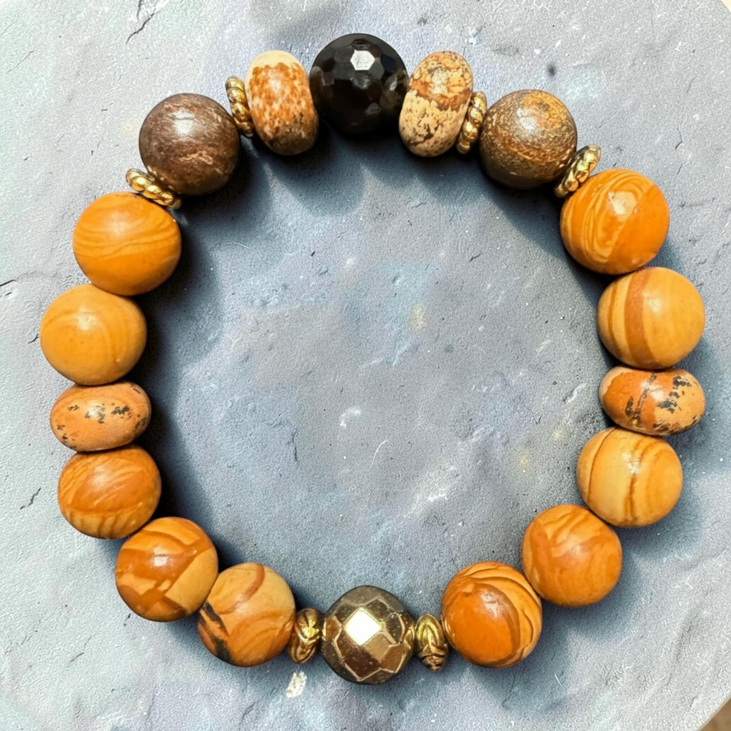 Golden Retriever gemstone bracelet resting on a soft natural gray stone background.